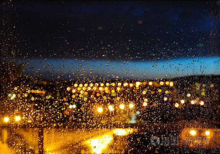 背景模糊雷雨过后玻璃和夜间城市灯光上有雨滴