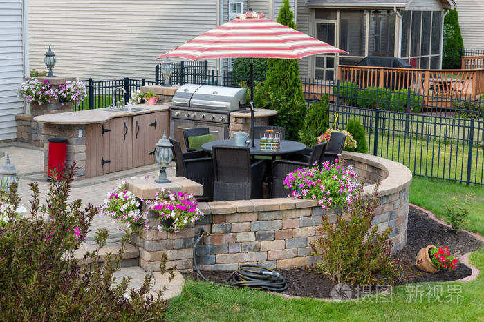 室外生活空间,在一个整洁的景观花园,在一个带有室外厨房和烧烤的外部