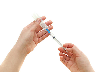 注射器与安瓿瓶在他手的女孩照片
