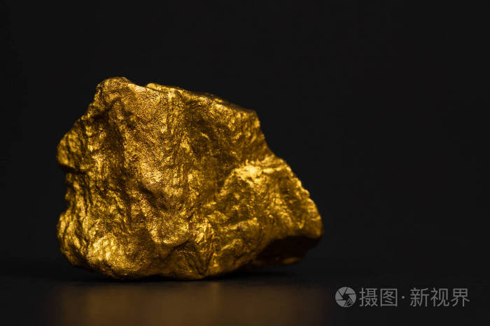 在黑色背景宝石或金石上特写金块或金矿石的财务和商业理念
