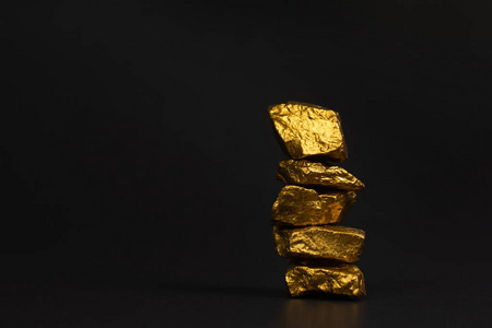 一堆金块或金矿石上的黑色背景宝石或一块金石金融和商业概念.照片