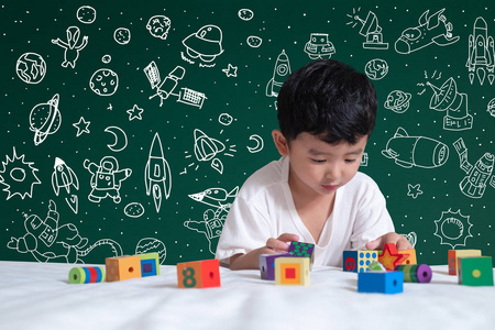 亚洲孩子学习通过发挥他对科学和空间冒险的想象力，手工绘制在绿色黑板教育回到学校和发现概念的想法。