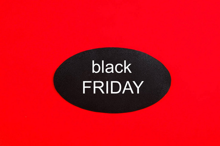 黑色星期五销售概念。 自1952年以来圣诞节购物季节开始的11月第四个星期五。黑色标签，白色文字，明亮的红色背景。 复制空间关闭
