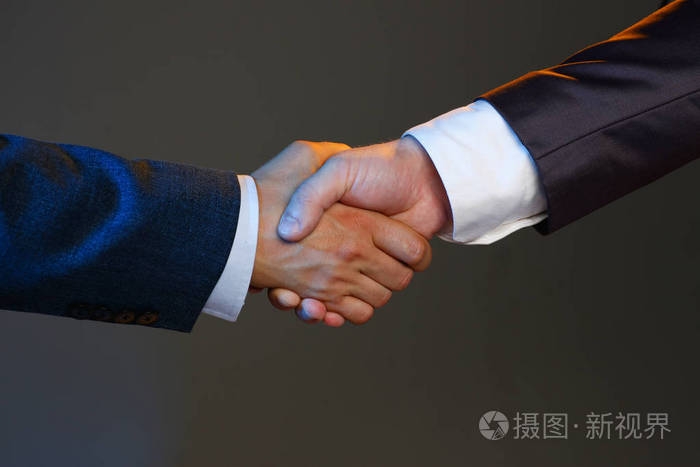 穿着西装的男人握手作为你好在办公室特写