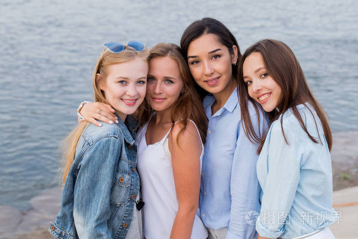 四位女性朋友的肖像看着友好的相机微笑快乐. 生活方式友谊概念