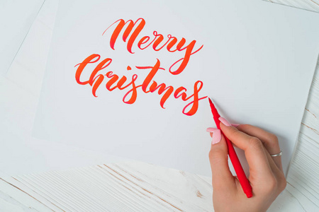 祝你圣诞快乐书法家用红色墨水写在白卡片上。书法。装饰品字体。刻字的艺术。平面设计, 手写, 创作概念
