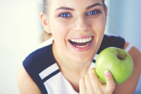 关闭绿色苹果的健康微笑的女人的肖像