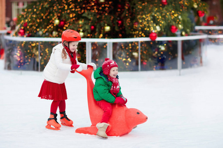 孩子们在冬季公园溜冰场滑冰. 孩子们在圣诞集市上滑冰.