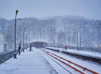 乌克兰基辅2018年3月4日在乌克兰基辅下雪时，DNipro地铁站站台上有乘客等待火车和工人清扫雪。