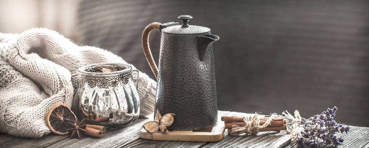宁静的生活舒适的客厅，带有家居装饰的元素，一杯茶，木桌上放着茶壶