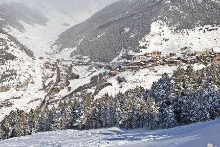 在阳光明媚的冬日，从斜坡上可以看到索德乌滑雪胜地埃尔塔尔特在安道尔的全景。 4.建筑物和山间的道路在远处是可以看见的