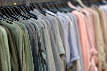 一排女人的衣服挂在商店里出售照片