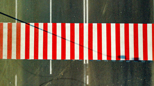 公路上有一个新的红白相间的人行横道。 空中景色