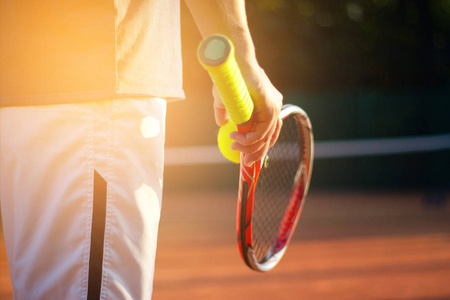 一个网球运动员准备发球在比赛中与阳光背景下的网球球