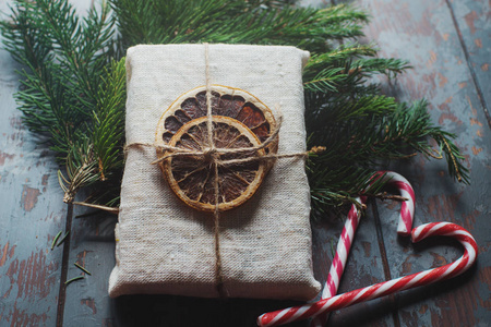 冷杉枝和圣诞礼物，裹着麻布，用干柠檬片装饰