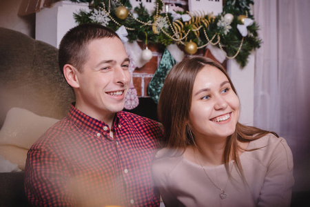 年轻夫妇在为玛丽圣诞节和新年装饰的房间里庆祝圣诞节