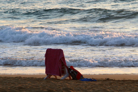 一把椅子矗立在地中海沿岸的海滩上