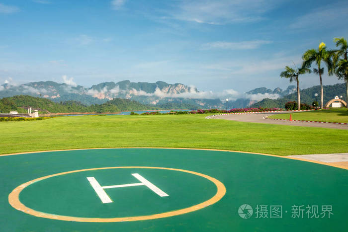 绿茵草地上的直升机停机坪背景是雪山