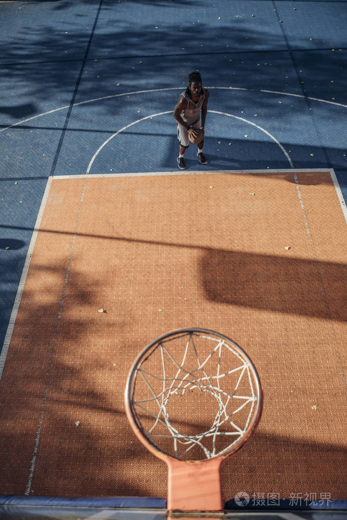 年轻的白种人在户外球场打篮球