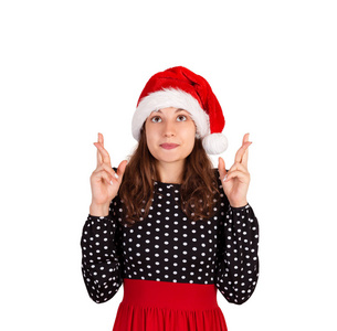 女人举起双手祈祷，梦见一些事情。 情感女孩在圣诞老人圣诞帽隔离在白色背景。 假日概念。