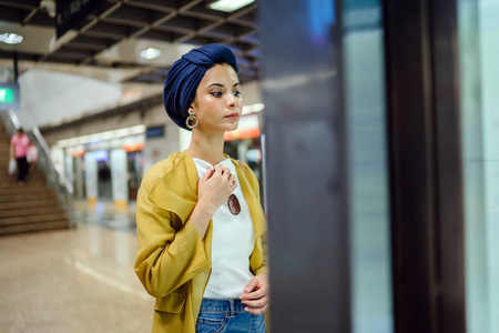 一位身材高大苗条年轻迷人的马来穆斯林妇女的时尚肖像，她穿着时尚的衣服和头巾。