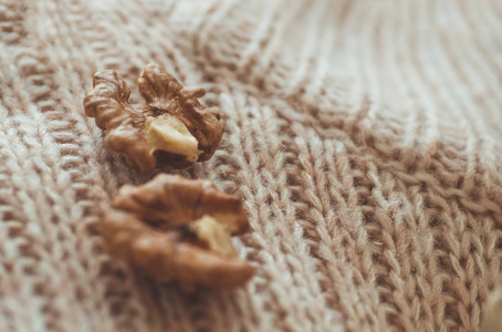 核桃毛衣。核桃仁在碗和整个核桃。舒适的秋天或冬天概念