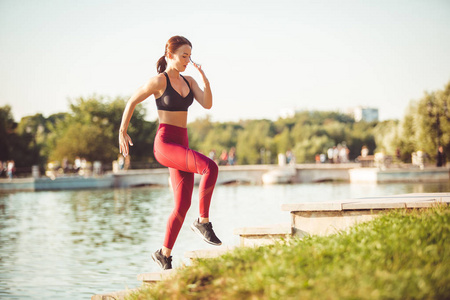 运动的女人在公园里做运动，在湖边做热身运动
