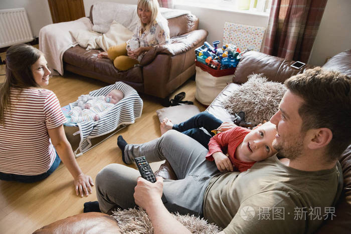 照片 三代家庭正在放松地看电视,在他们家的客厅里聊天.jpg