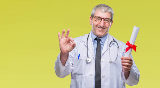 英俊的高级医生，男人拿着学位纸在孤立的背景上做OK标志，手指很好的符号