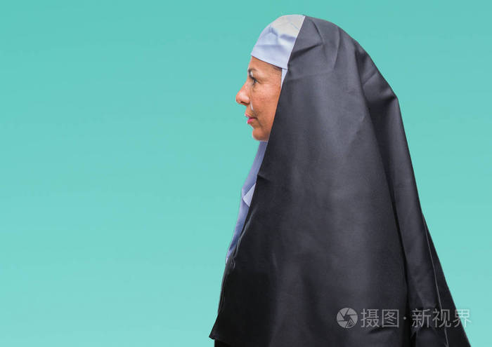 中年高级基督教修女妇女在孤立的背景下看着侧面放松的轮廓自然的脸