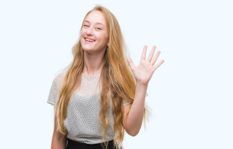 金发少女穿着鼹鼠衬衫，用手指举着第五个手指，微笑着自信和快乐。