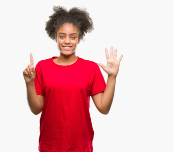 年轻的非洲美国妇女在孤立的背景显示和举指第六，同时微笑自信和快乐。