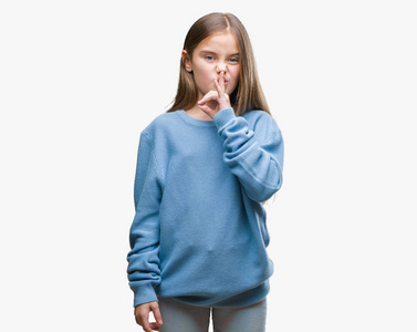 年轻漂亮的女孩穿着冬天的毛衣，在孤立的背景上要求嘴唇上用手指安静。 沉默和秘密的概念。