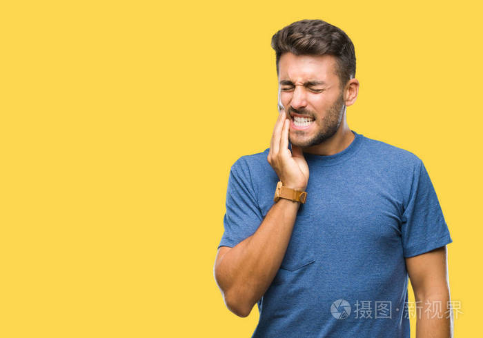 年轻的帅哥在孤立的背景下,用手摸嘴,因为牙痛或牙齿上的牙齿疾病