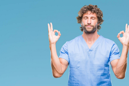 英俊的西班牙裔外科医生，男人在孤立的背景下放松，微笑着闭着眼睛，用手指做冥想手势。 瑜伽概念。