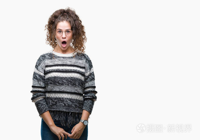 的黑发卷发年轻女孩戴着眼镜,在孤立的背景下害怕和震惊,惊讶的表情