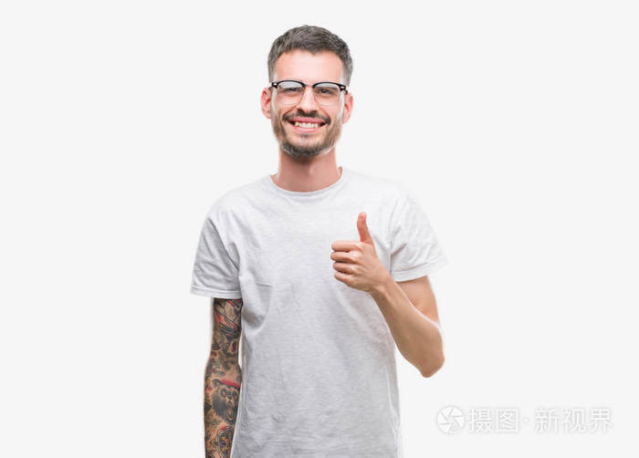 年轻的纹身成年男人用手做快乐的竖起大拇指的手势赞许的表情看着相机