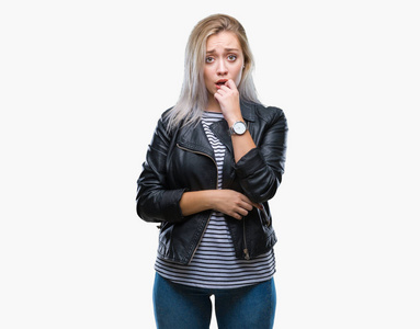 年轻的金发女人穿着时尚夹克，在孤立的背景上看起来压力和紧张，双手咬着嘴的指甲。 焦虑问题。
