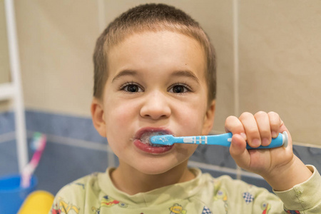 这个男孩在浴室里刷牙已经4年了。 快关门。 小男孩在浴室里刷牙