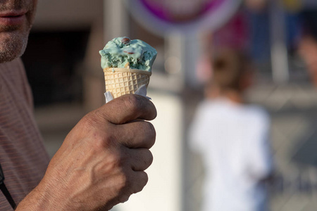 一个中年男人在街上吃冰淇淋。