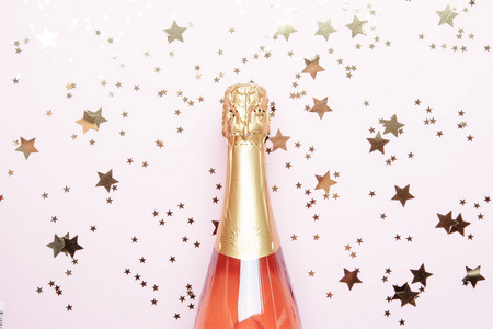 圣诞节或新年粉红色背景，带一瓶起泡葡萄酒玫瑰香槟和黄金装饰的顶级景观