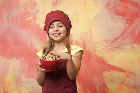 孩子，在红色的厨师帽，围裙和巧克力饼干的小女孩