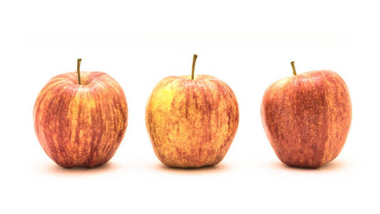 工作室拍摄了三个新鲜的生有机苹果分离在白色背景上。 垂直条纹斑驳和整体橙色的颜色皮肤。 甜美细腻的质地和芳香的味道