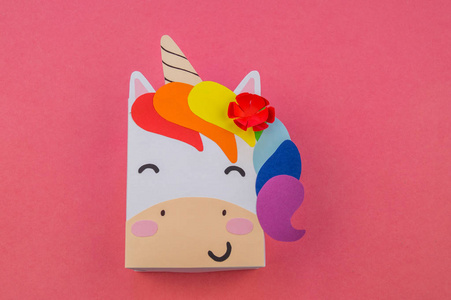 粉红色背景上的纸独角兽. 大师班手工制作. 一种神奇的动物.