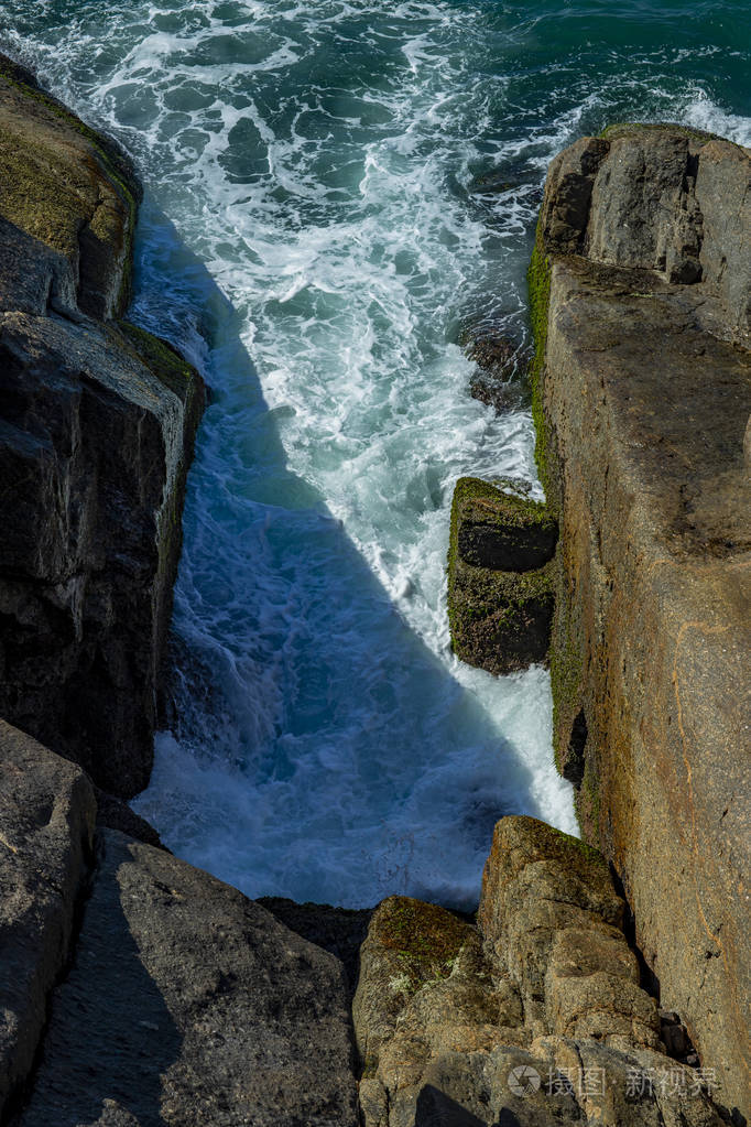 海浪在巴西的岩石上破碎深蓝色的海浪撞击悬崖海浪撞击岩石悬崖巨大的