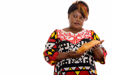 工作室拍摄的胖黑色非洲女人拿着面包边想