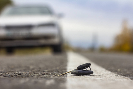 丢失的汽车钥匙躺在道路上模糊的背景上，波克效应
