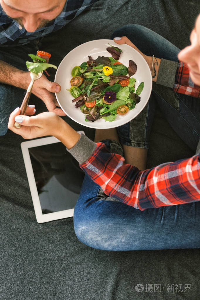 快乐的女人喂饭男人躺在家里睡觉照片-正版商用图片13ggf0-摄图新视界