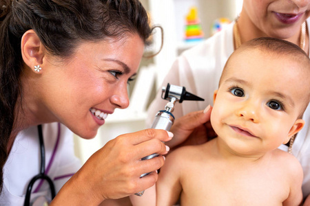 有吸引力的医生检查婴儿的耳朵，提供专业护理