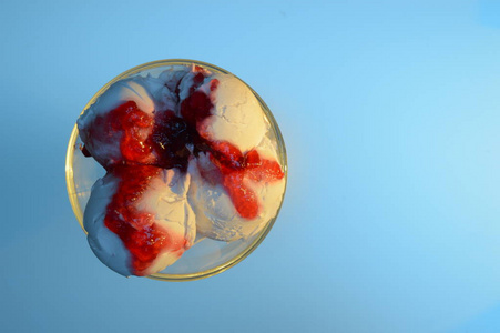 蓝色背景下红色果酱白色冰淇淋的俯视图